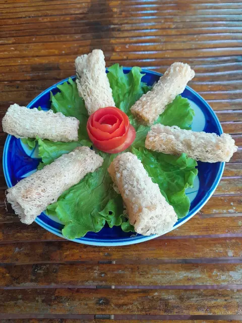 Crispy spring rolls served on a bed of fresh green herbs