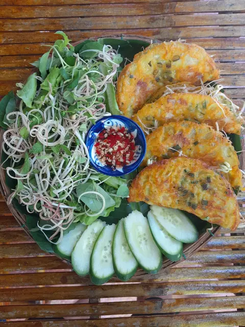 Golden Vietnamese rice pancakes with fresh herbs and dipping sauce